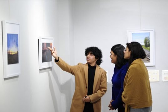 A 17-year-old photographer Idant Dikshit explaining details of his photos to visitors at his solo 2 day photo exhibition - 'Lessons from a Passport' at Punjab Kala Bhawan, Sector 16, Chandigarh.