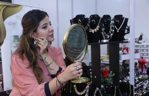 A woman tries an earring at the 3 day 'Global Fashion' Exhibition which has started at Kisan Bhawan, Sector 35, Chandigarh.