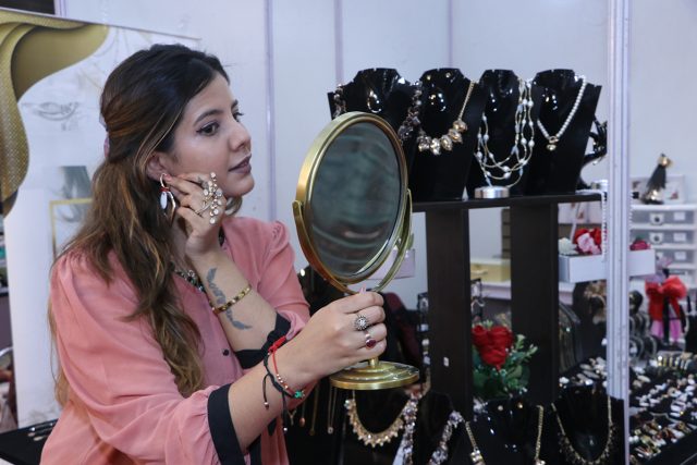 A woman tries an earring at the 3 day 'Global Fashion' Exhibition which has started at Kisan Bhawan, Sector 35, Chandigarh.